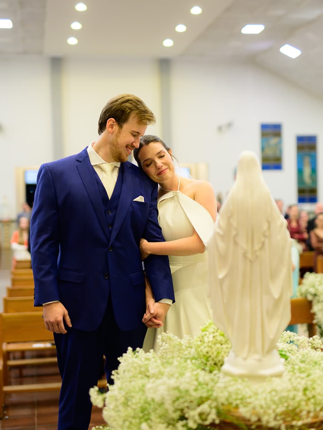 Noivo de azul-marinho com a noiva na igreja